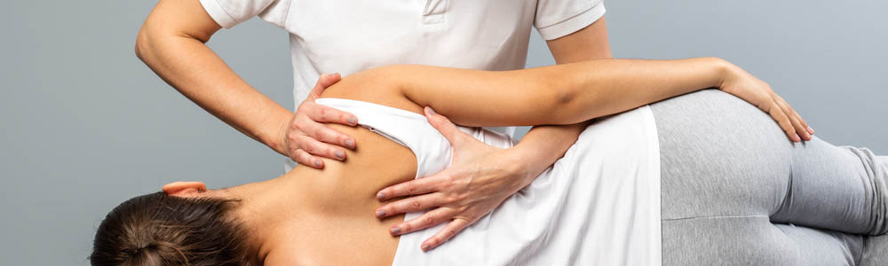 Close-up of female chiropractor doing a back adjustment on a female patient at a clinic Close-up of female chiropractor doing a back adjustment on a female patient at a clinic